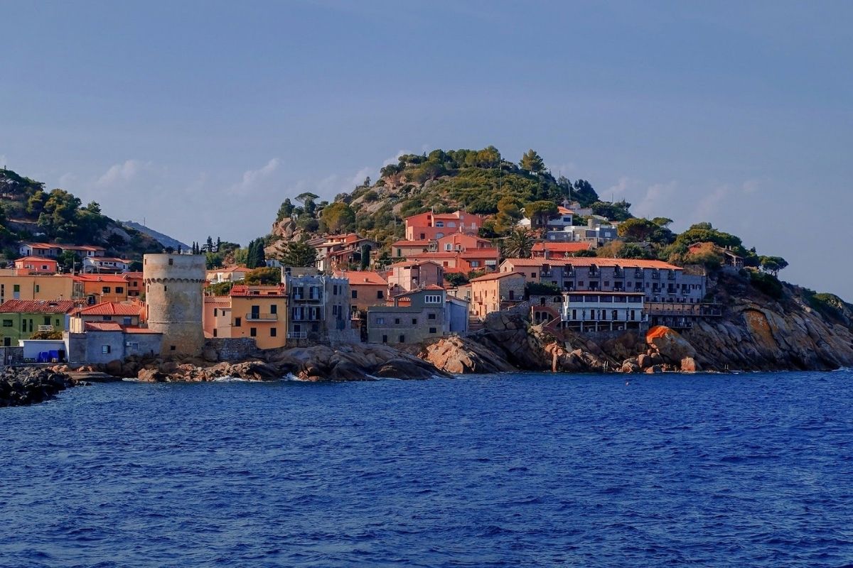 Vista panoramica di Pula, con il mare e la macchia mediterranea sullo sfondo